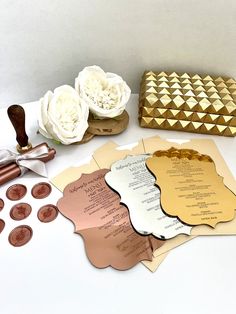 the wedding stationery is laid out on top of the table with flowers and coins