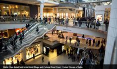 people are walking around in a mall with escalators and stairs leading up to the second floor