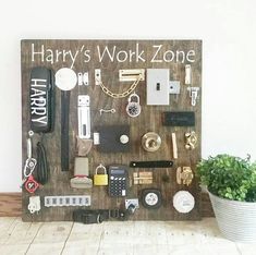 a wooden sign that says harry's work zone with various items on it and a potted plant next to it