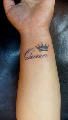 a woman's wrist tattoo with the word queen written on it and a crown