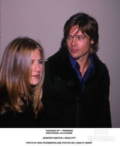 a man and woman standing next to each other in front of a white wall wearing fur coats