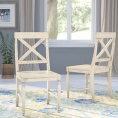 two white chairs sitting in front of a window on top of a carpeted floor