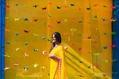 a woman standing in front of a display with origami birds