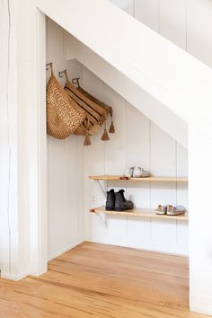 a pair of shoes is hanging on the wall next to shelves with baskets and purses