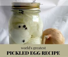 a jar filled with pickled egg next to an onion