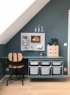 a room with blue walls and white storage containers on the shelf next to an ironing board