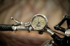 a close up of a clock on the handlebars of a bike