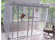 a bird in a cage sitting on top of a floor next to a chair and table