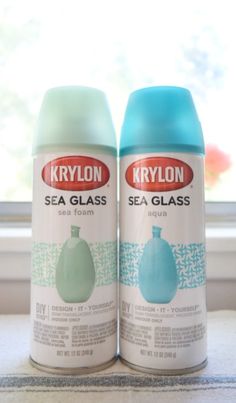 two cans of krylon sea glass sitting on a window sill next to each other