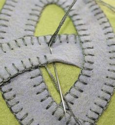 a pair of scissors and some thread on a piece of fabric that has been stitched together