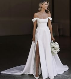 a woman in a white wedding dress holding a bouquet