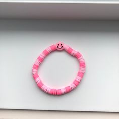 This beautiful preppy bracelet is an amazing gift. It's two shades of pink and there is a pink smiley face in the middle. You can put it on you wrist easily by rolling it. Pink Bracelet Wristband For Beach, Playful Pink Wristband For Friendship, Trendy Handmade Pink Bracelets, Playful Handmade Pink Wristband, Adjustable Pink Wristband For Everyday, Playful Pink Beaded Bracelets For Friendship, Playful Pink Beaded Bracelets As Gift, Playful Pink Bangle Bracelets, Cute Pink Wristband With Letter Beads