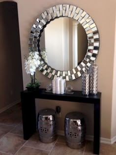 there is a mirror and vases on the table in this living room with tile flooring