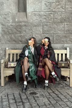 two women sitting on a bench with their faces covered