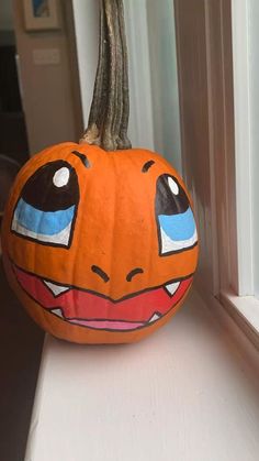 a painted pumpkin sitting on top of a window sill