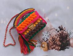 a colorful purse sitting on top of a table next to a christmas ornament