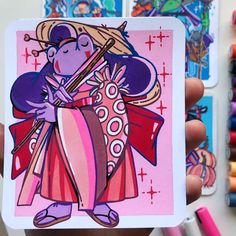 a hand holding up a card with an image of a woman in pink and purple