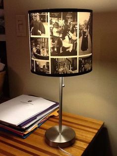 a lamp that is sitting on top of a table next to some books and papers