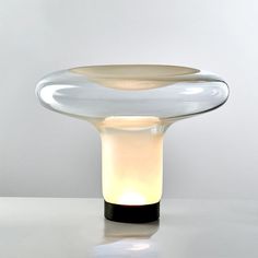 a table with a glass bowl on it and a lit candle in the middle next to it