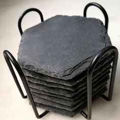 a stack of slate coasters with black iron handles