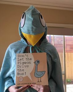 a person wearing a bird costume and holding a book in front of their face with the caption don't let the pigeon drive the bus