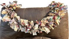 a brown leather couch covered in lots of different pieces of paper on it's side