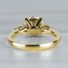 a yellow gold engagement ring with an oval center stone