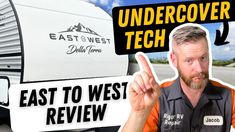 a man pointing to the side of an rv that is under cover with text reading east west tech