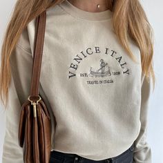 This is a professionally embroidered sweatshirt. 👚MATERIAL  We use Gildan as our blanks. If the color purchased isn't available, I may sometimes use a different brand (more premium). Gildan Heavy Blend are 50/50 polyester and cotton. ▪️ SIZE  Sizes are unisex. Please check the size chart before you purchase.  💧 CARE:  Machine wash cold, inside-out, gentle cycle with mild detergent and similar colors.   Tumble dry low, or air-dry for longest life. Every item is made to order, creating less fabr Women Crewneck Sweatshirt, Crew Necks For Women, Trendy Beige Crew Neck Sweatshirt, Crewneck Aesthetic, Beige Sweatshirt, California Sweatshirt, Brown Sweatshirt, Embroidery Shoes, Embroidery Tshirt