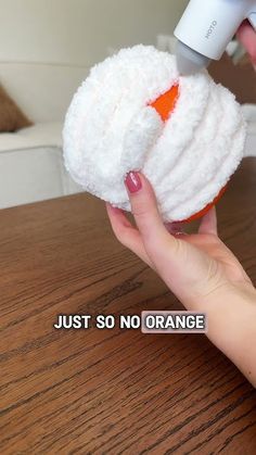 someone is using an orange and white object to clean the table