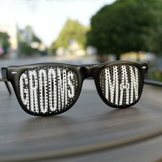 a pair of sunglasses with the word god's man written on them sitting on top of a wooden table