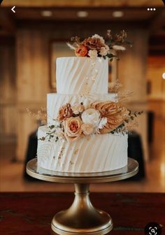 a white wedding cake with flowers on top