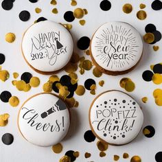 three decorated cookies sitting on top of a table covered in confetti and black dots