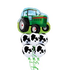 a green tractor balloon with black and white balloons