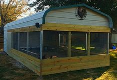 a chicken coop in the back yard with an enclosed area for it to sit inside