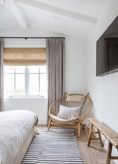 a bed room with a neatly made bed and a flat screen tv on the wall