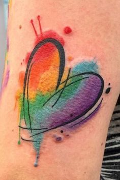 a colorful heart tattoo on the arm