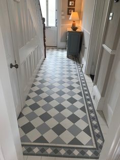 an entry way with a checkered tile floor and white door frames, along with two lamps on either side of the doorway