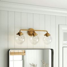 a bathroom with a mirror, sink and lights on the wall next to each other