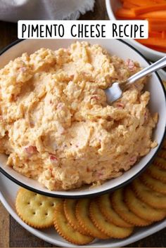 a bowl filled with dip surrounded by crackers and carrots