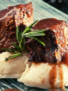 some food is sitting on a glass plate with sauce and gravy over it