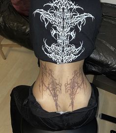 the back of a woman's head with tattoos on it