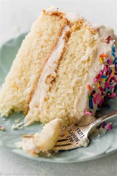 a slice of white cake with sprinkles on a plate next to a fork