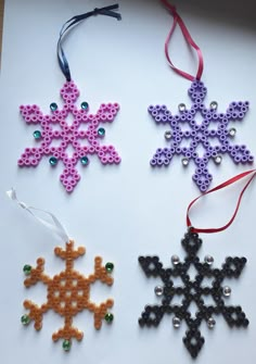 beaded snowflake ornaments are displayed on a white surface