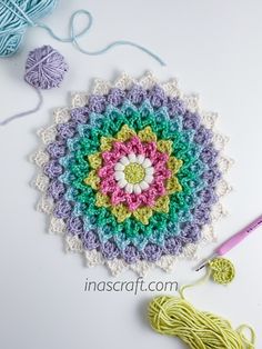 a crocheted doily with yarn and scissors on the table next to it