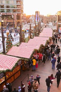 many people are walking down the street with christmas decorations and lights on them, while others walk by