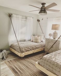 two twin beds in a bedroom with white walls and wooden floors, one is made from pallets