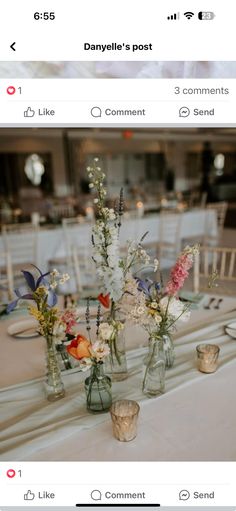 the table is set with flowers in vases and place settings for guests to sit at