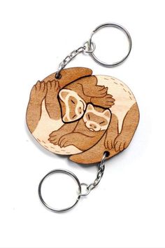 a wooden key chain with an image of a monkey on it's face and two hands in the shape of a circle