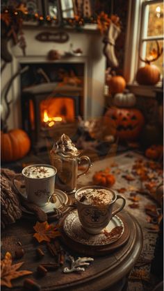 two cups of hot chocolate sitting on top of a table next to a fire place